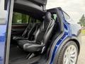 Interior view of a 2020 Tesla Model X showcasing two black leather seats with a modern design and spacious layout