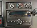 Dashboard controls of a 2020 Chevrolet Express including knobs for temperature and air conditioning along with a digital display and various buttons for audio functions