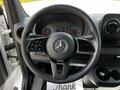 The steering wheel of a 2020 Mercedes-Benz Sprinter with control buttons and the logo prominently displayed