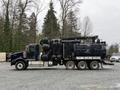 A 2018 Kenworth T800 truck with a black tank and various equipment mounted on the back