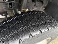 Close-up of a wet tire tread from a 2000 Ford F-450 showcasing deep grooves and patterns designed for traction