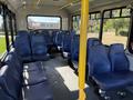 Interior of a 2019 Chevrolet Express bus featuring blue seats arranged in rows with ample space in the aisle