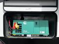 A green Onan QG 4000 EVAP generator housed in a compartment with wires and tags attached on the side