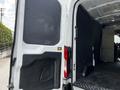 A 2022 Ford Transit van with an open rear door revealing a spacious and empty cargo area
