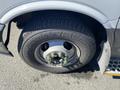 A close-up of a tire on a 2020 Chevrolet Express showing the wheel rim and lug nuts with a tread pattern visible on the tire