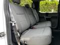 Interior view of the backseat of a 2020 Ford F-350 Super Duty featuring grey fabric upholstery and seat belts