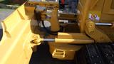 Close-up of the hydraulic mechanism and blade attachment of a 2013 Komatsu D37PX-22 bulldozer in yellow color