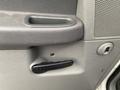 Close-up of the interior door handle and speaker grille of a 2008 Dodge Ram 5500 with a textured grip handle and a small circular door lock button