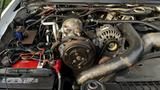 A close-up view of a 2007 Ford F-550 engine with visible components including the alternator battery and various hoses and wiring