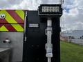 A 2007 Ford F-550 with a mounted floodlight on a pole and a red and yellow reflective design on the side of the vehicle