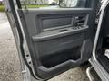 A close-up view of the driver's side door panel of a 2012 RAM 3500 featuring control buttons and a textured surface