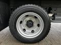 Close-up of a silver wheel with a black tire on a 2021 Mitsubishi FE featuring five lug nuts and a patterned tread design