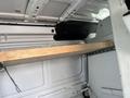 A 2008 Ford Econoline interior showing a wooden plank supported by metal brackets inside the cargo space