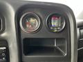 Dashboard of a 2006 GMC C5000 displaying gauges for temperature and oil pressure with a compartment below for storage