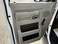 Interior door panel of a 2013 Ford Econoline featuring a handle a window crank and compartments for storage