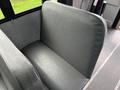 A gray vinyl seat in a bus interior with a smooth finish and a simple design
