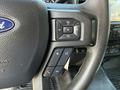 Close-up of the steering wheel in a 2019 Ford F-550 featuring control buttons for volume and audio settings