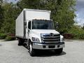 A white 2020 Hino 338 box truck with a silver front grille and orange marker lights is parked in a lot