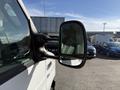 A 2012 Ford Econoline E-450 side mirror showing a clear reflection and designed for commercial use