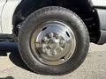 A close-up of a chrome wheel rim mounted on a large all-terrain tire from a 2012 Ford Econoline E-450