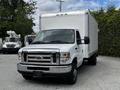 A white 2018 Ford Econoline box truck parked with a large cargo area at the back and a front grille featuring the Ford logo