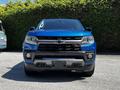 A blue 2021 Chevrolet Colorado with a black grille and chrome accents is positioned facing forward in the image
