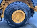 A close-up of a large tire from a 2016 Hyundai HL940 construction vehicle showcasing its rugged tread and yellow rim design