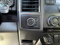 The interior control panel of a 2018 Ford F-150 featuring knobs for traction control and audio settings
