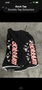 Black MMA shorts with "WARRIOR" in red lettering and various graphic designs featuring skulls and masks