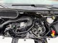 Close-up of the engine compartment of a 2022 Ford Transit showcasing various engine components and parts including hoses and electrical connections