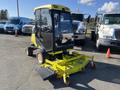 A yellow 2010 Kubota F3990 with a glass enclosed cabin and a large mowing deck positioned in the foreground