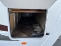 Interior storage compartment of a 2013 Outdoor Wind River trailer featuring a tiled floor and wooden shelves