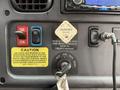 Dashboard controls of a 2014 Freightliner B2 including door controls parking brake lever and various warning labels
