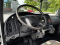 The interior of a 2012 Freightliner M2 106 featuring the steering wheel dashboard controls and pedals