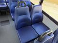 Two blue upholstered seats in a vehicle with textured surfaces and handles on the backrests