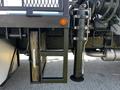 Close-up of a 2012 Freightliner M2 112 featuring a hydraulic cylinder mounted to the chassis with a support frame and wooden blocks visible