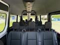 Interior view of a 2023 Mercedes-Benz Sprinter showcasing rows of black seats with seat belts attached