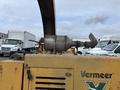 A yellow 2015 Vermeer Corporation BC1200XL wood chipper with a large exhaust pipe and a distinctive V-shaped logo on its side