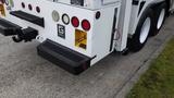 A white 2012 International 7400 truck showcasing the rear with taillights and a utility compartment on the side