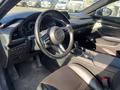 Interior view of a 2023 Mazda MAZDA3 showing the steering wheel dashboard and center console with controls and gear shift