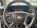 Steering wheel and dashboard of a 2017 Chevrolet Express featuring a Chevy badge and various gauges and controls