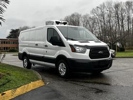 A 2016 Ford Transit van in white with a black grille and silver wheels parked at an angle