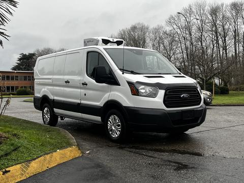 A 2016 Ford Transit van in white with a black grille and silver wheels parked at an angle