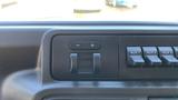 Dashboard controls of a 2013 Ford Econoline featuring buttons for volume and auxiliary inputs