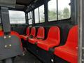 Interior seating area of a 2023 Prinoth Panther T6 featuring six red seats with seatbelts arranged along one side