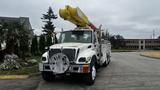 A 2006 International 7500 truck equipped with a yellow aerial lift on top and various tools and compartments along the sides