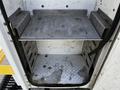A metal shelf inside the rear compartment of a 2008 Ford F-550 with a textured floor and a smooth surface on the shelf