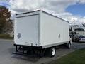 A 2007 GMC W5500 18 foot cube van with a white cargo box and a black chassis parked on a street