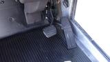 Close-up of the floor area inside a 2004 Freightliner MT45 showing a rubber floor mat and two foot pedals for acceleration and braking