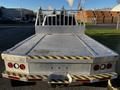 A 2014 RAM 5500 flatbed truck with a silver metal bed and yellow caution stripes on the edges